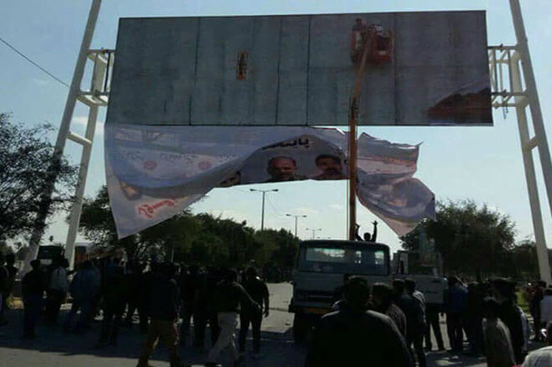 Iranian protesters rip down billboard honouring “shrine defenders”
